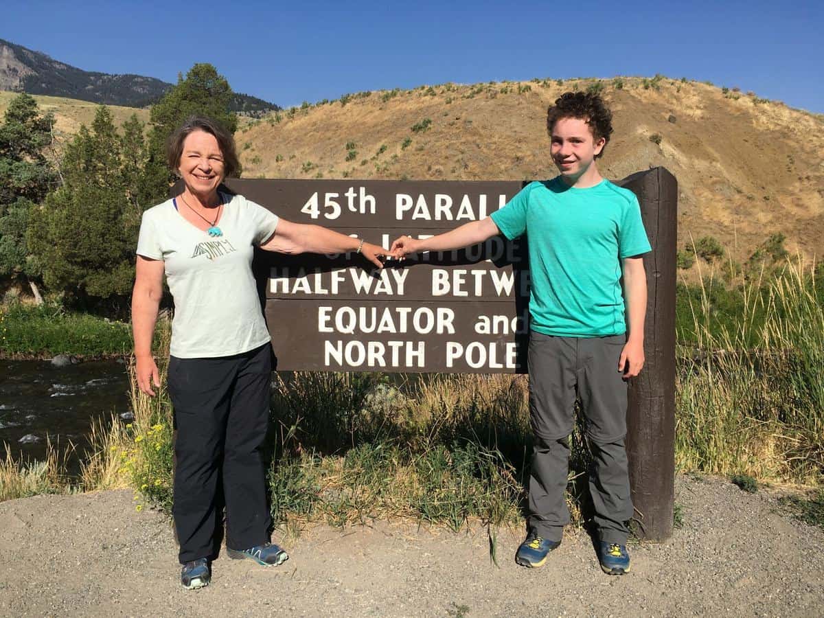 Amanda Rose and her son at the 45th Parallel sign north of Yellowstone National Park in August 2018, Amanda looking all trim at 140 pounds.