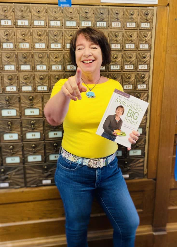 Amanda Rose standing with the book in her little post office