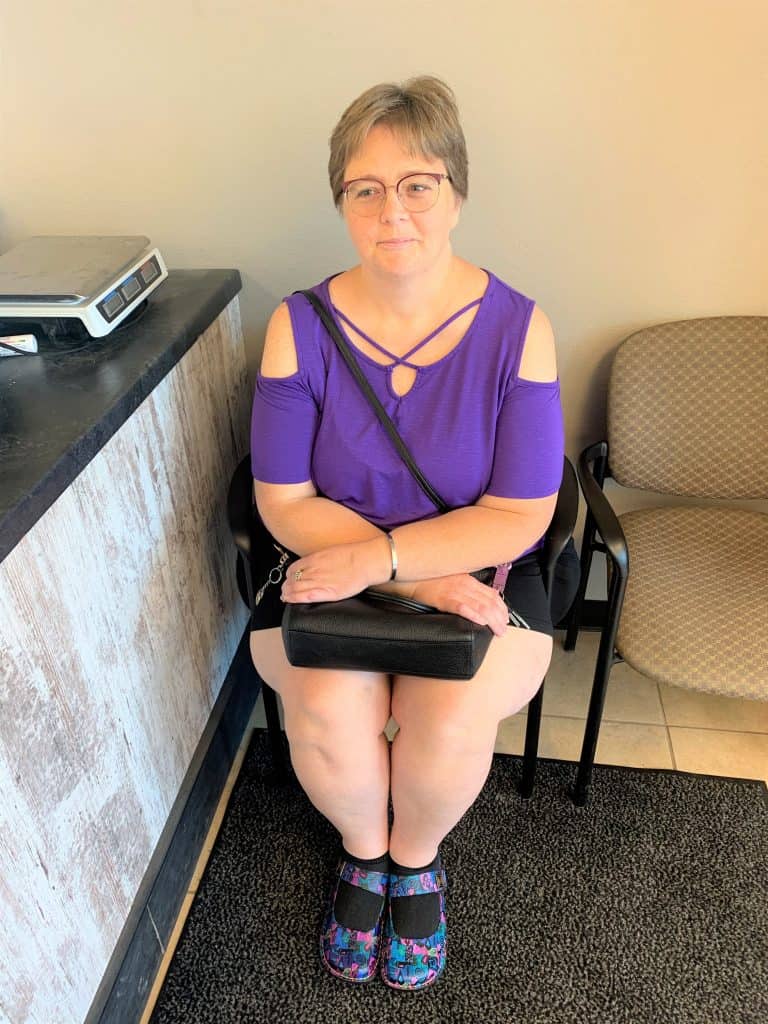 Tonia, sitting in chair with arms