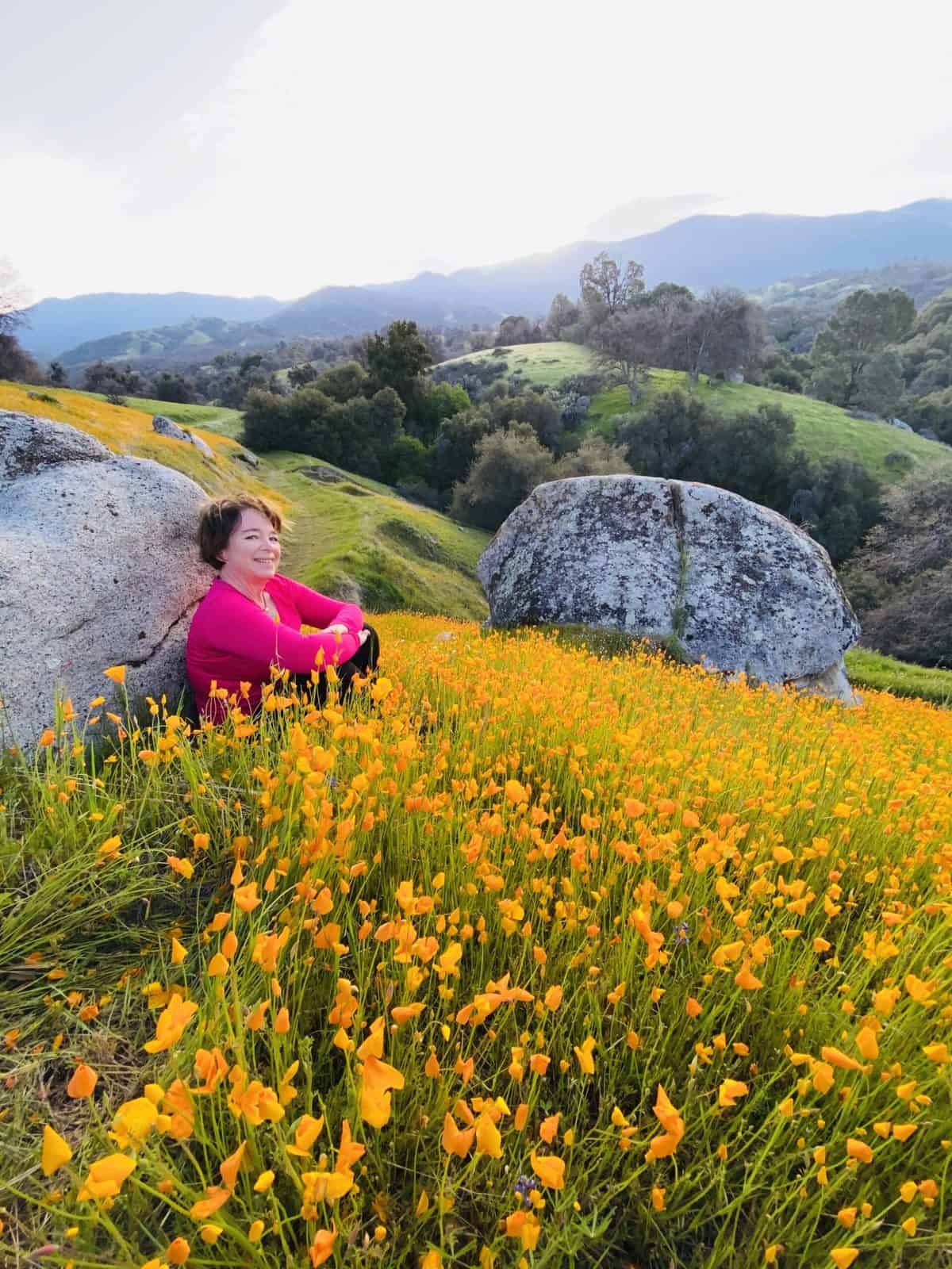 Amanda Rose sitting in a field of poppies