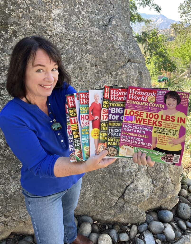 Amanda Rose holding 8 magazines that feature the community